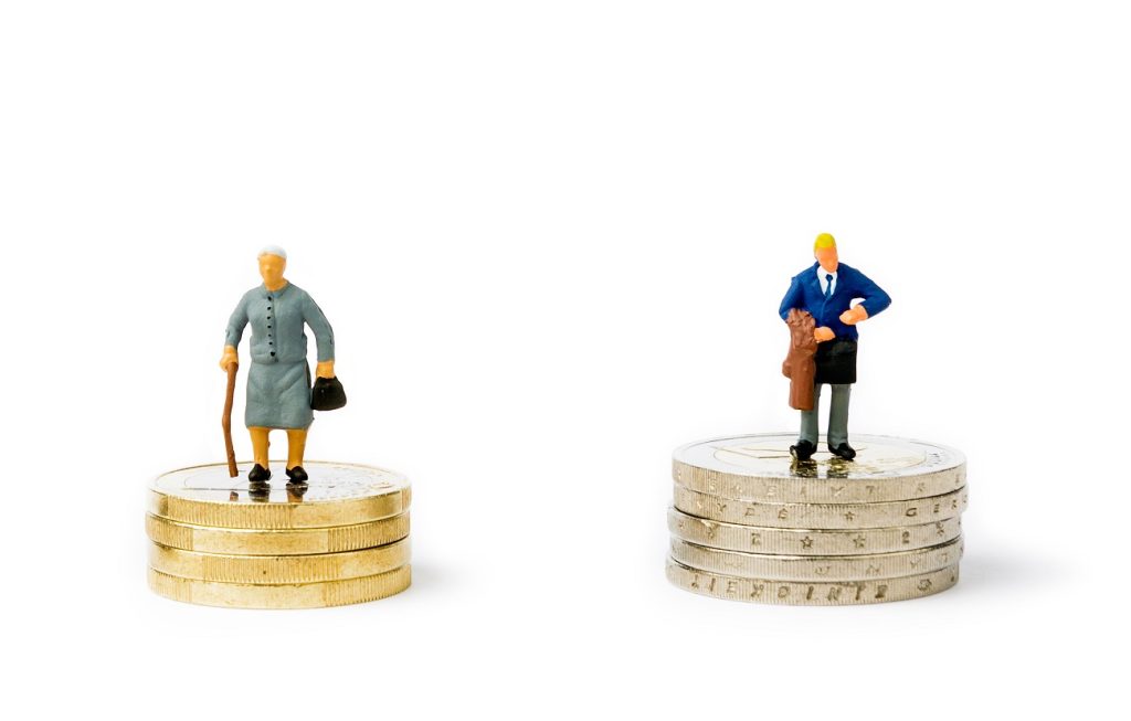 Small figurines and stacks of Euro coins on bright background. Economic inequality by gender. Inequality, starvation wages and income concept. Gender pay gap.