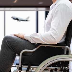 Mann im Rollstuhl am Flughafen.