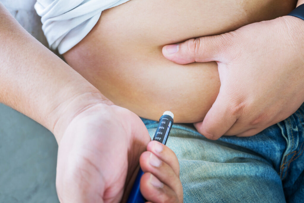 Mann spritzt sich Insulin wegen Diabetes.